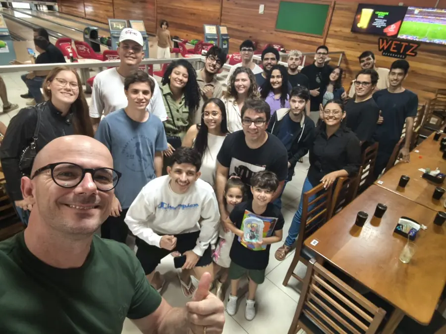 Cerca de vinte e cinco pessoas, entre integrantes do LEDS e familiares, posam entre as mesas de um boliche