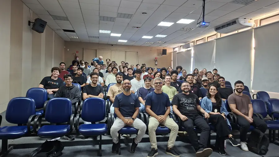 Grupo numeroso reunido nas poltronas do auditório