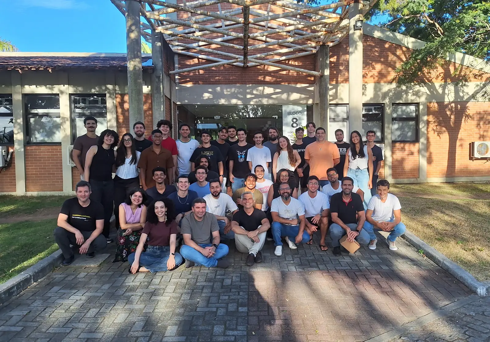 Cerca de quarenta integrantes do LEDS posam ao ar livre em frente ao Bloco 8