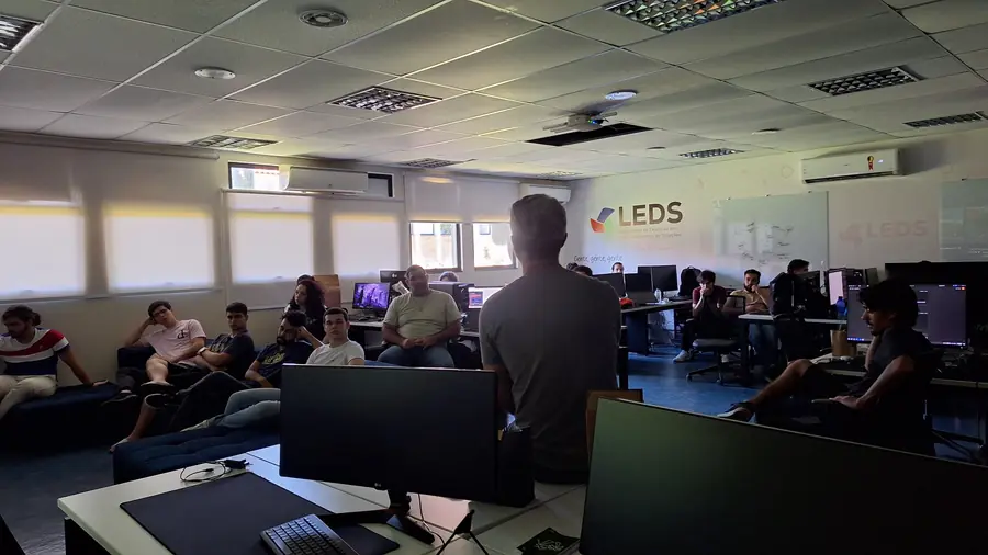 Equipe reunida no laboratório, com a marca do LEDS na parede